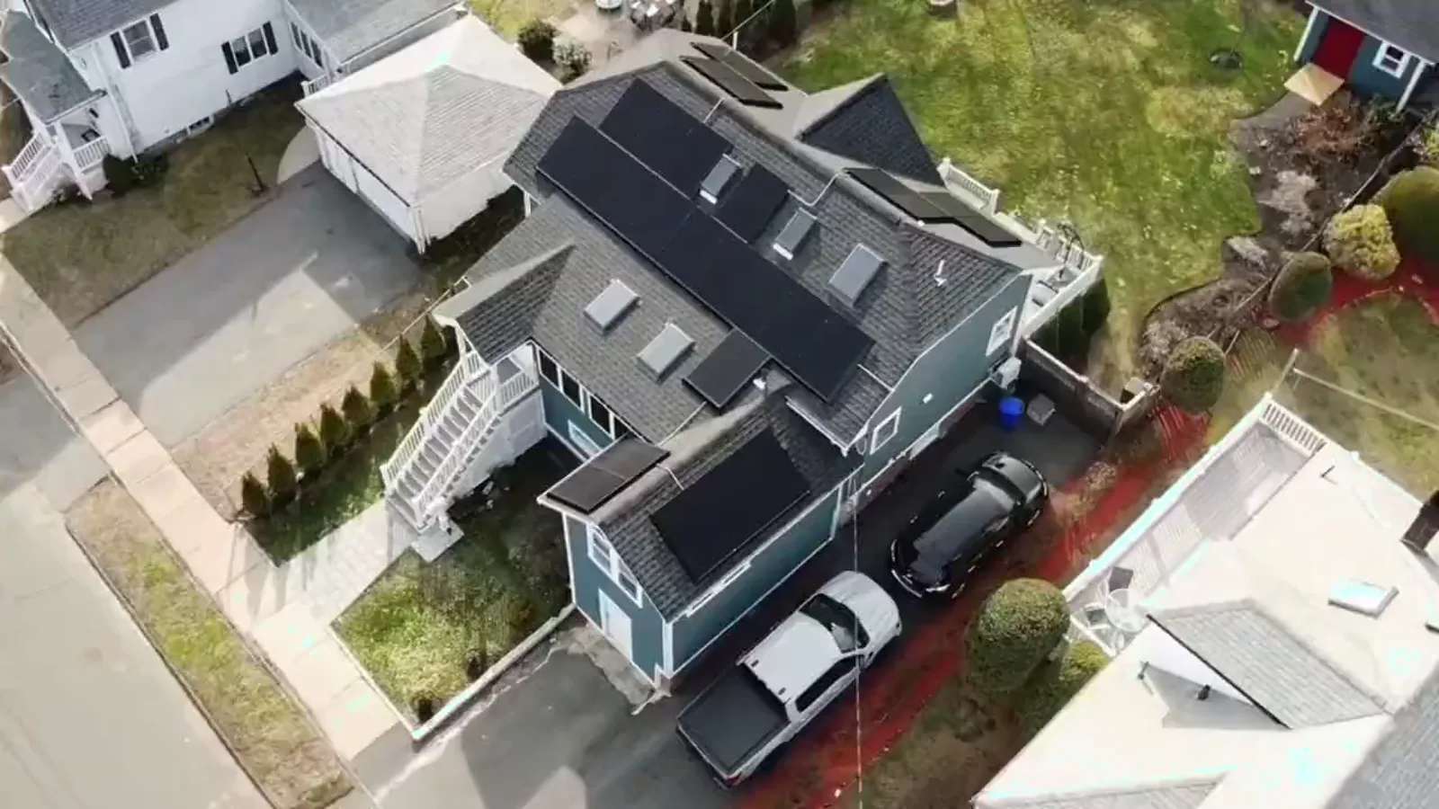 Aerial view of a blue two-story home with solar panels on the roof