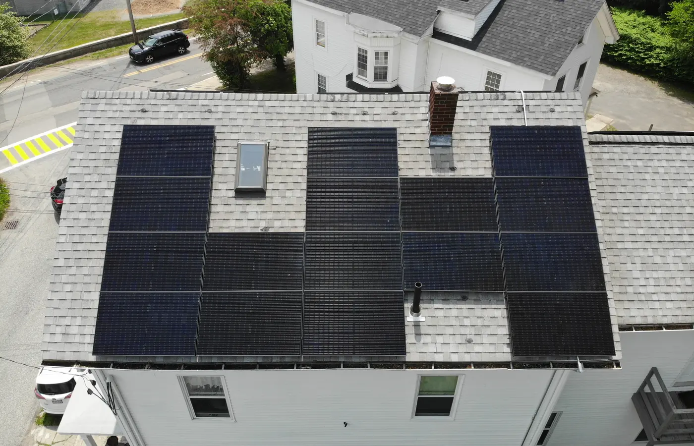 Black solar panels installed on a gray shingle roof
